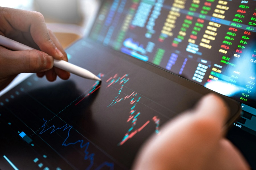 Someone is analysing a price chart on a screen using an Apple Pencil.