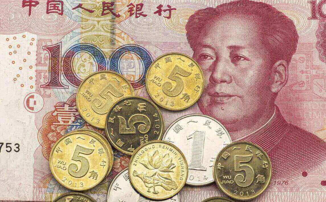 A stack of 5 jiao and 1 yuan coins is placed on top of a 100 RMB note.