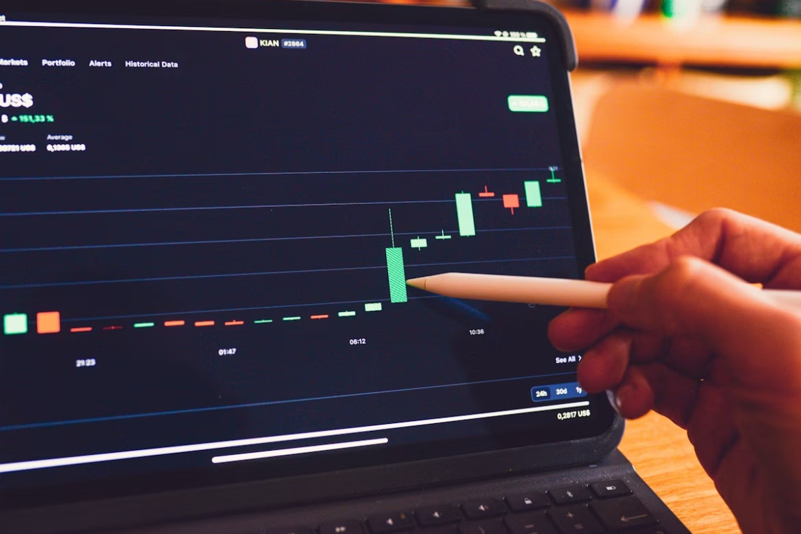 A trader uses an Apple Pencil to analyse a live trading chart on a tablet.