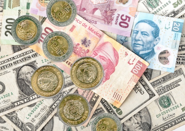 Billetes de dólares estadounidenses junto al peso mexicano