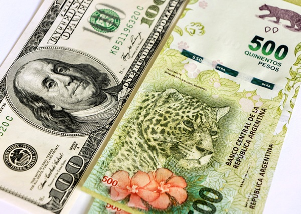 Billetes del dólar estadounidense junto al peso argentino