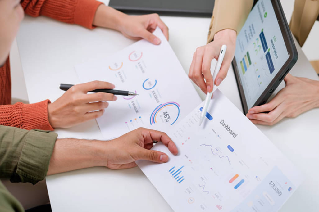 Financial advisor presenting charts and data on a tablet during couple client meeting.