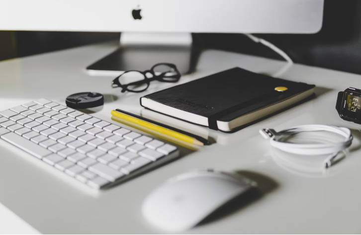 雑然とした白いテーブルの上のキーボードとマウス 雑然とした白いテーブルの上のキーボードとマウス