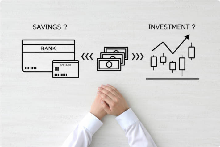 The hand of a person who is unsure whether to save or invest money The hand of a person who is unsure whether to save or invest money