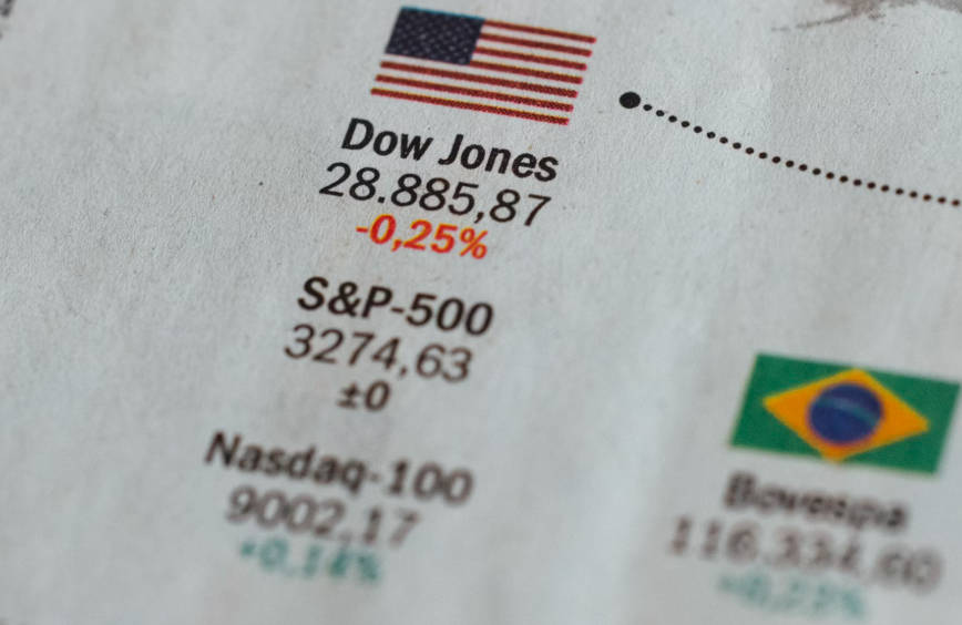 Financial papers displaying data on the Dow Jones, S&P 500, and Nasdaq Financial papers displaying data on the Dow Jones, S&P 500, and Nasdaq