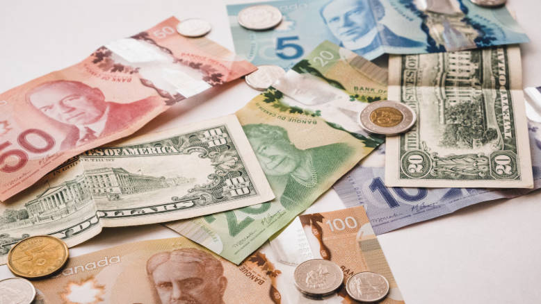 A pile of money sitting on top of a table A pile of money sitting on top of a table