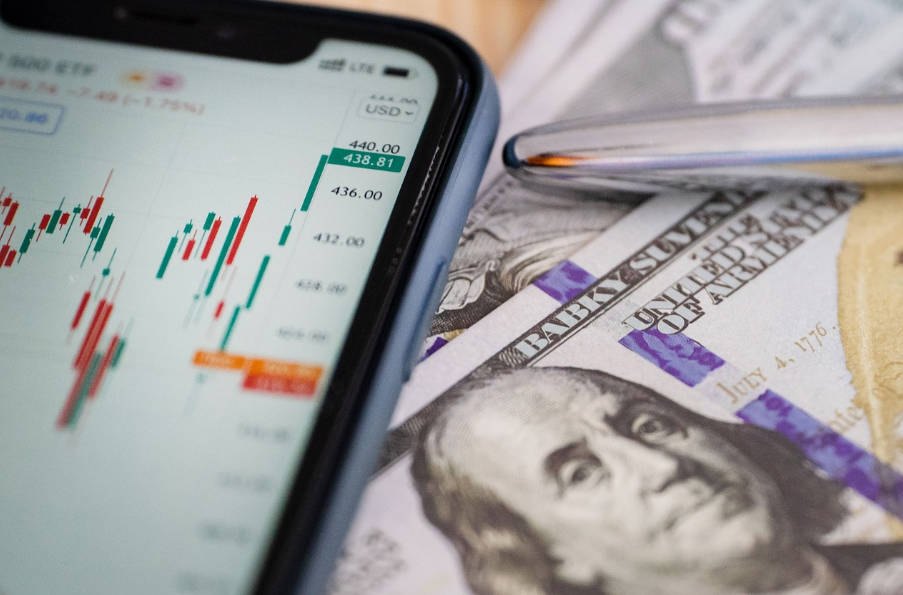 Trading Charts Beside a US Dollar Bank Note