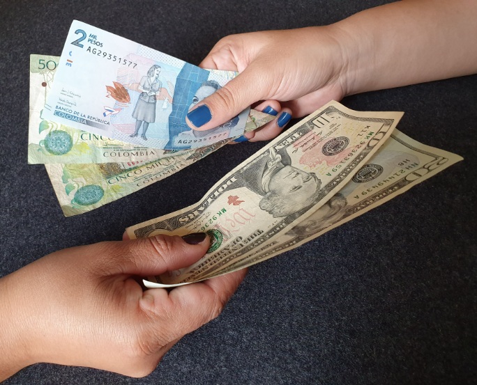 Dólares estadounidenses junto a pesos colombianos