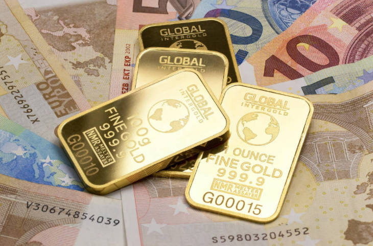 Gold Bars Lying on Top of Euros