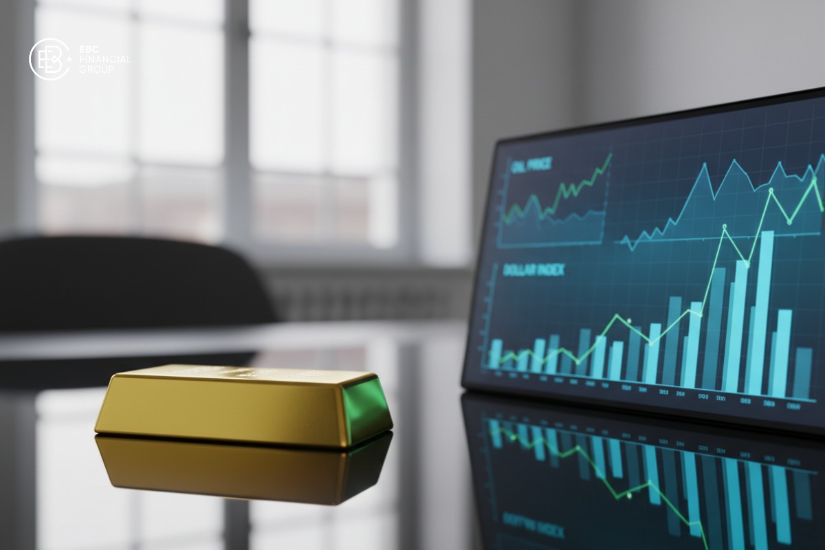 Cận cảnh thỏi vàng đặt cạnh màn hình giá dầu và Dollar Index